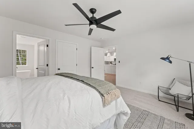 a spacious bedroom with a bed and ceiling fan