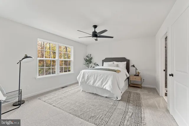a spacious bedroom with a bed and ceiling fan