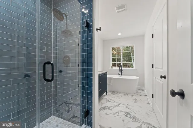 a bathroom with a double vanity sink a mirror and a bathtub