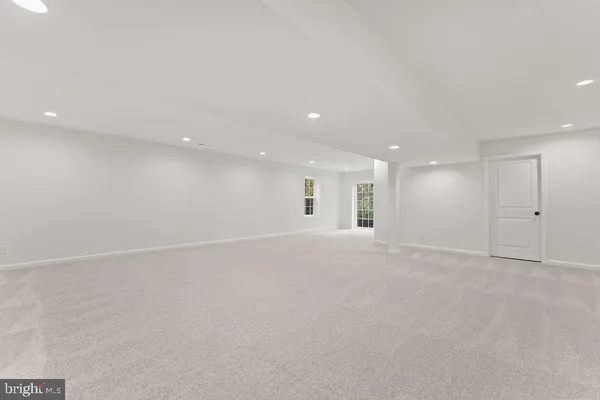 an empty room with an entryway and fan