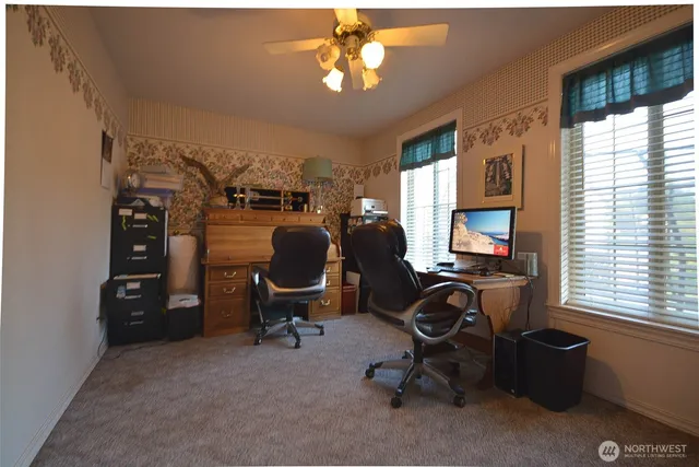 a view of a workspace with furniture and a window