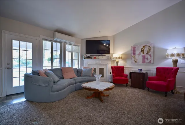 a living room with furniture a flat screen tv and a fireplace