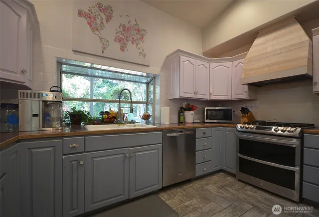 a kitchen with granite countertop a stove and white cabinets