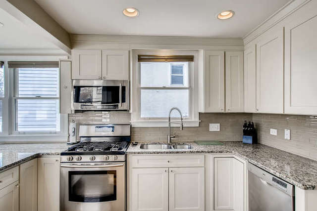 126 Southcote Road Riverside, IL 60546 - Photo 9 of 31 a kitchen with stainless steel appliances granite countertop white cabinets granite counter tops and a window