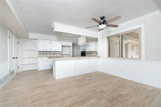 a view of kitchen with wooden cabinet and a window