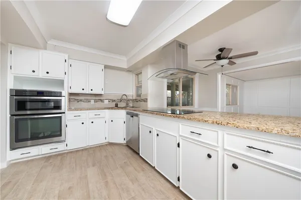 a kitchen with granite countertop white cabinets and white appliances