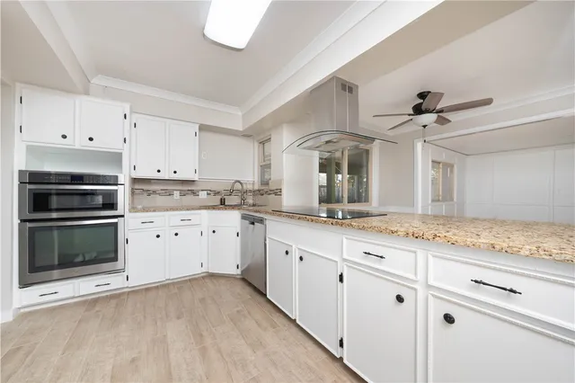 a kitchen with granite countertop white cabinets and white appliances