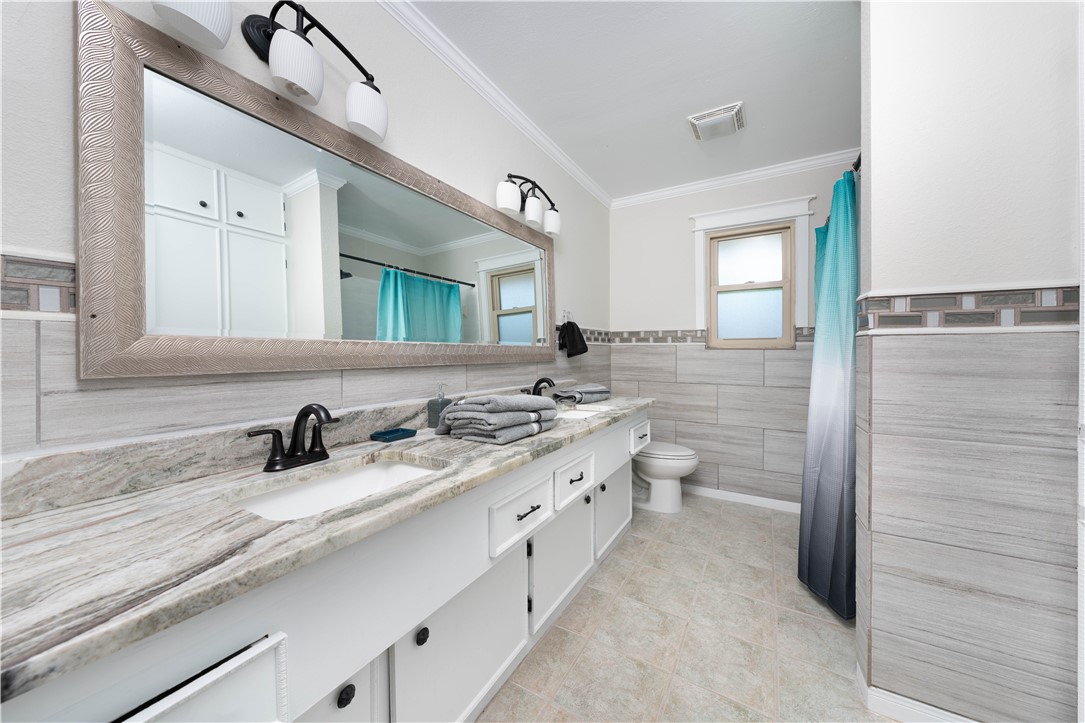 6402 Clearlake Circle Corpus Christi, TX 78413 - Photo 24 of 29 a bathroom with a double vanity sink and a mirror