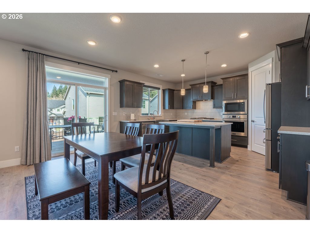 9149 North Hargrave Street Camas, WA 98607 - Photo 5 of 36 a kitchen with a table chairs refrigerator and cabinets