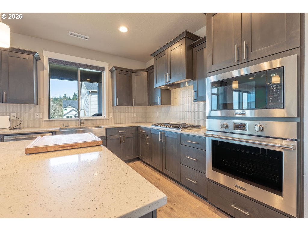 9149 North Hargrave Street Camas, WA 98607 - Photo 7 of 36 a kitchen with stainless steel appliances granite countertop a stove a sink and a microwave