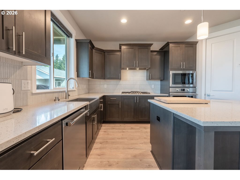 9149 North Hargrave Street Camas, WA 98607 - Photo 8 of 36 a kitchen with stainless steel appliances granite countertop a sink a stove and a refrigerator