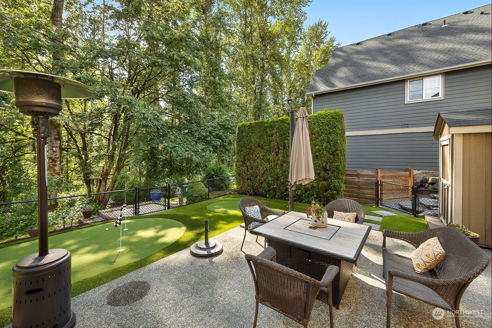18564 Rainier View Road Southeast Monroe, WA 98272 - Photo 27 of 34 a view of a patio with table and chairs potted plants and palm tree