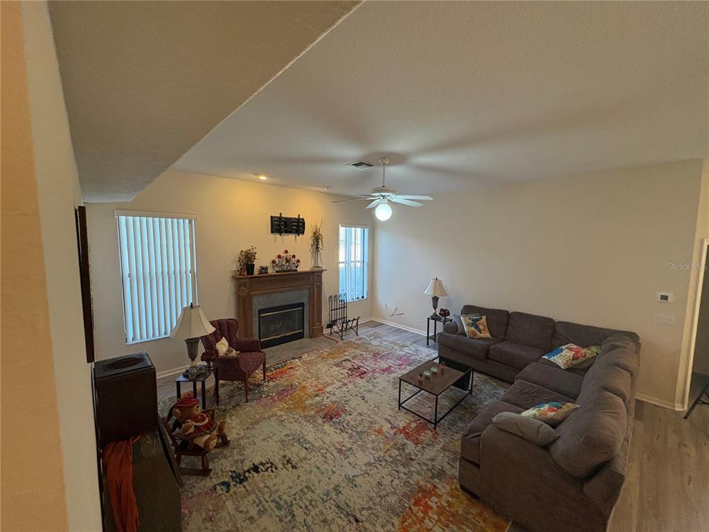 2810 Highview Bend Lakeland, FL 33812 - Photo 11 of 35 a living room with furniture a flat screen tv and a refrigerator