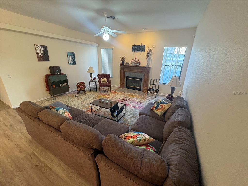 2810 Highview Bend Lakeland, FL 33812 - Photo 12 of 35 a living room with furniture a fireplace and a flat screen tv