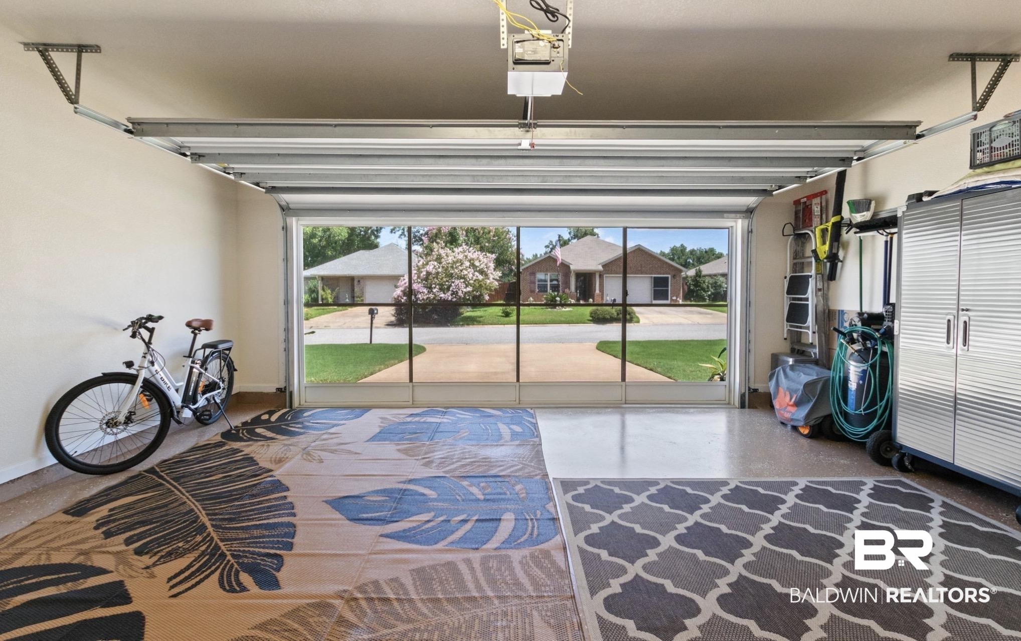 1676 Abbey Loop Foley, AL 36535 - Photo 22 of 31 Spacious garage featuring a screened door, overhead garage door track system, painted walls, and built-in storage cabinetry