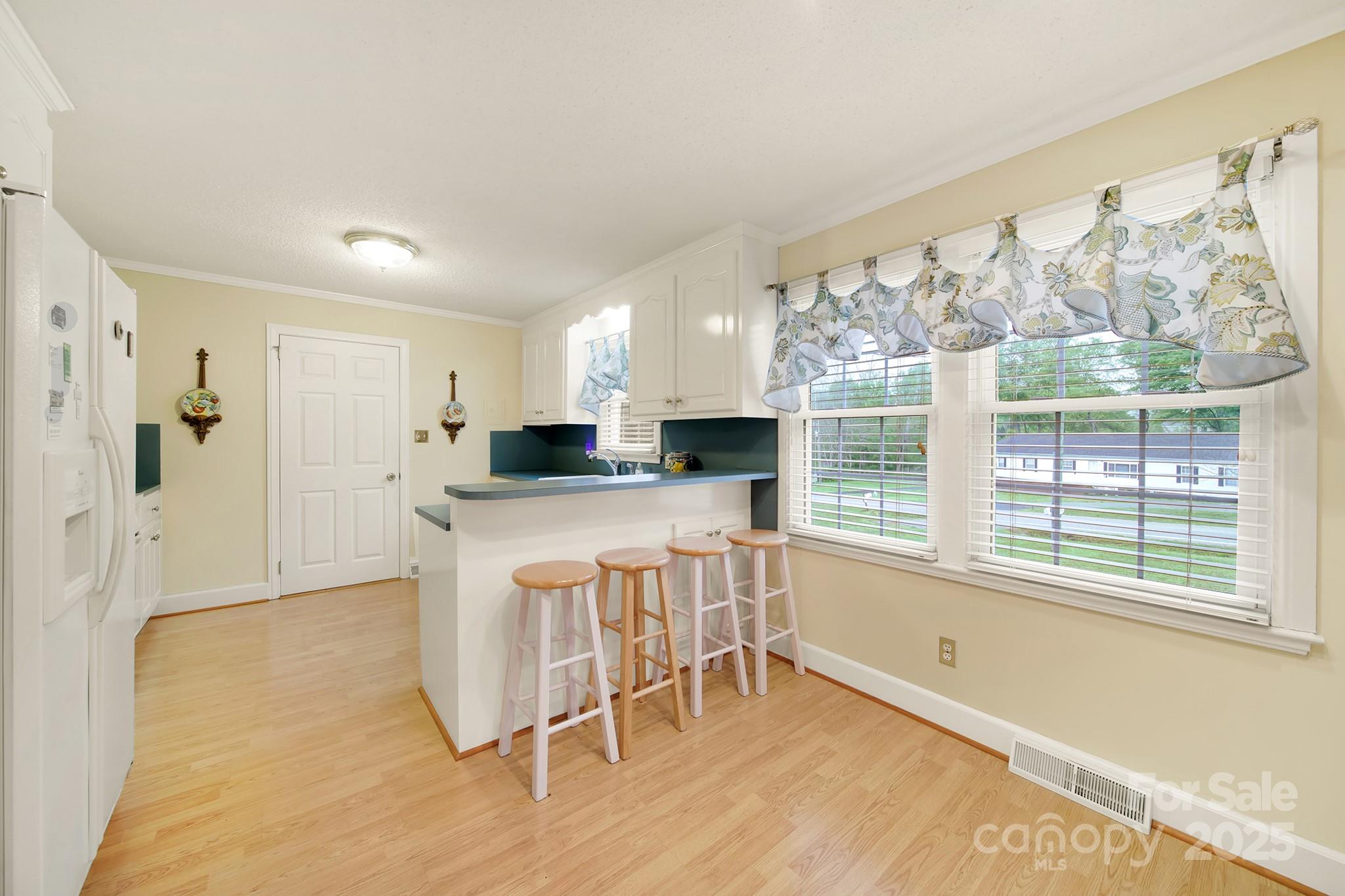 4462 Flat Creek Road Lancaster, SC 29720 - Photo 11 of 35 a kitchen with a table chairs refrigerator and window
