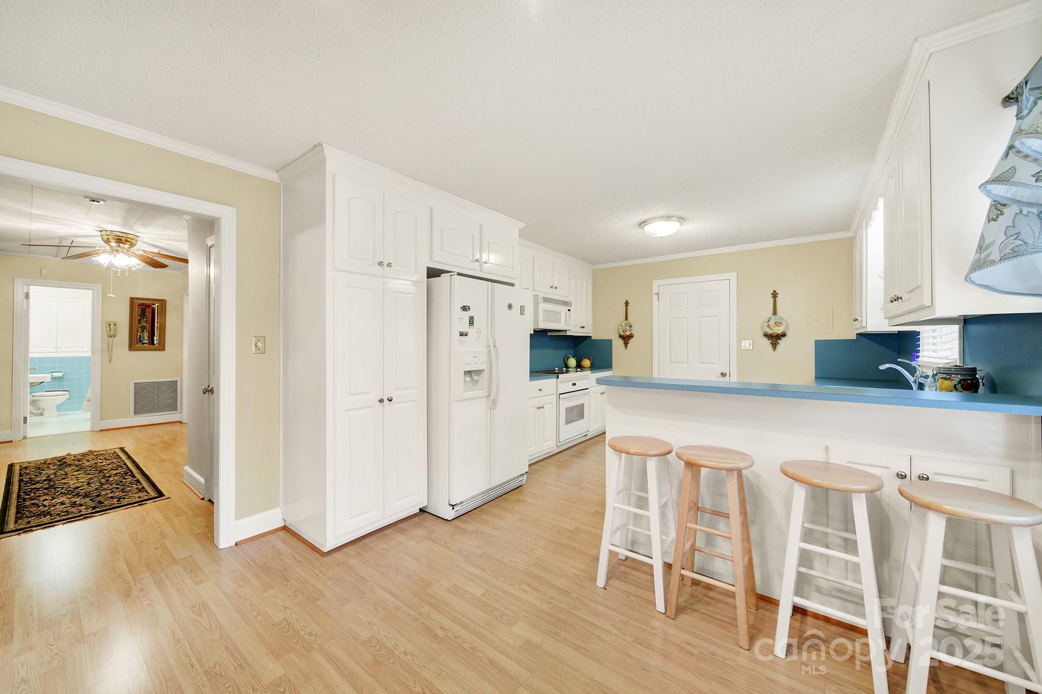 4462 Flat Creek Road Lancaster, SC 29720 - Photo 7 of 35 a kitchen with white cabinets and wooden floor