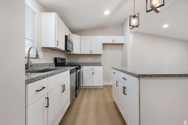 96 Barrington Way Layton, UT 84041 - Photo 4 of 28 Kitchen with white cabinetry, light wood-type flooring, light stone countertops, a kitchen island, and stainless steel appliances