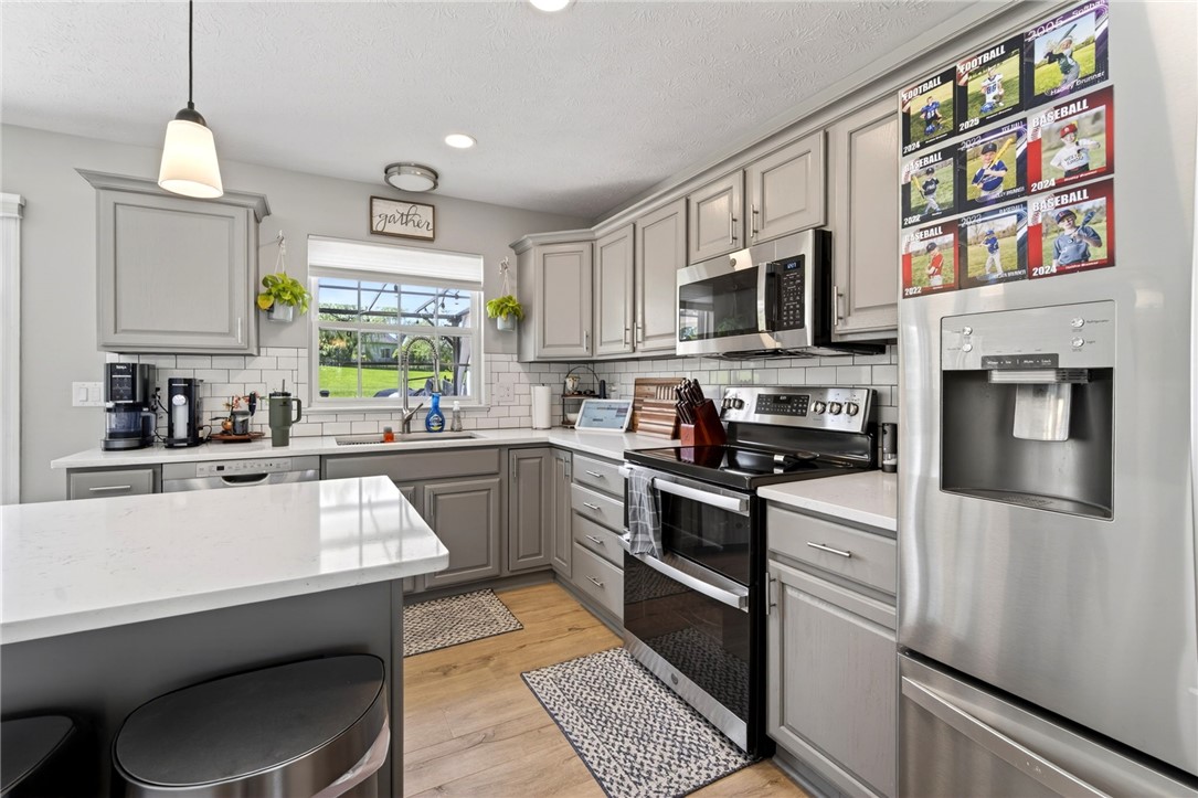 39 Holly Court Springboro, OH 45066 - Photo 9 of 42 This modern kitchen features light gray cabinetry, stainless steel appliances, and a beautiful white tiled backsplash.