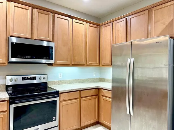 a kitchen with stainless steel appliances granite countertop a refrigerator a stove a microwave and cabinets