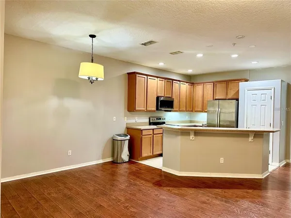 a kitchen with stainless steel appliances granite countertop a sink a stove top oven a counter space and cabinets