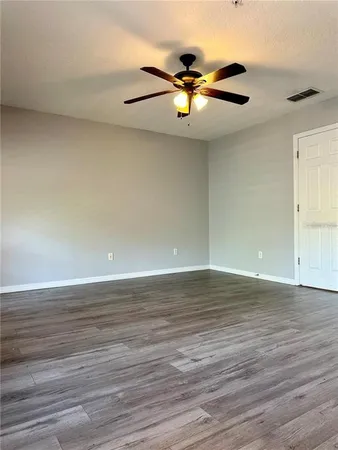 a view of an empty room with wooden floor