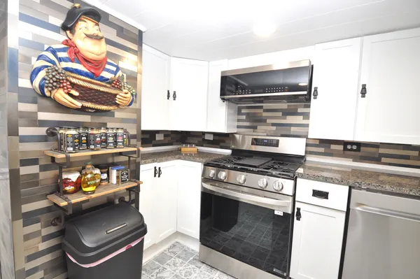 a kitchen with stainless steel appliances granite countertop a stove and a microwave