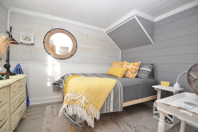 a bedroom with a bed and a mirror on dresser
