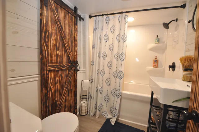 a bathroom with a sink and mirror with bathtub