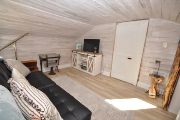 a spacious bedroom with a bed a couch and large window