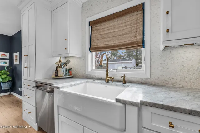 a kitchen with stainless steel appliances granite countertop white cabinets and a stove a oven with white countertops