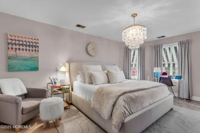 a bedroom with bed and a chandelier