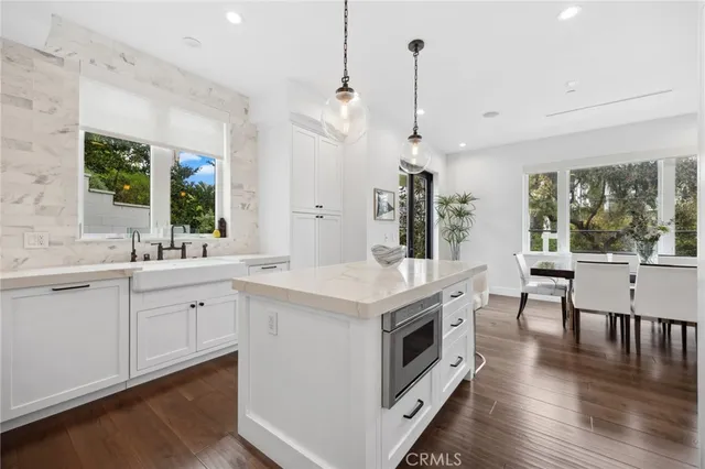 a kitchen with white cabinets and appliances