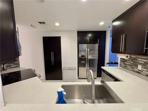 a kitchen with stainless steel appliances kitchen island granite countertop a refrigerator and a stove