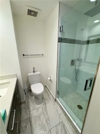 a bathroom with a granite countertop shower and a toilet