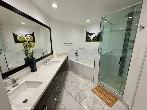 a bathroom with double vanity sink a mirror and shower