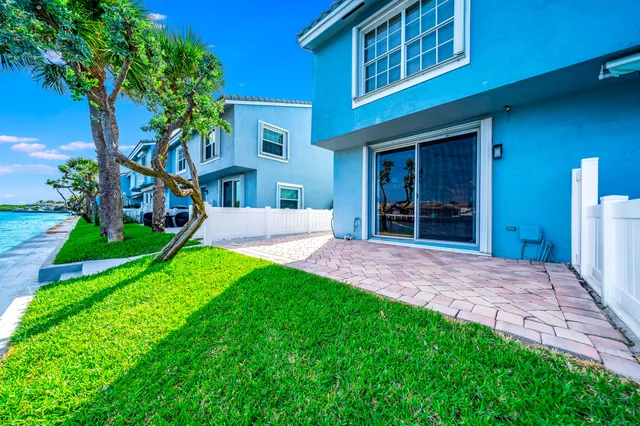 a view of an house with backyard space and a tree