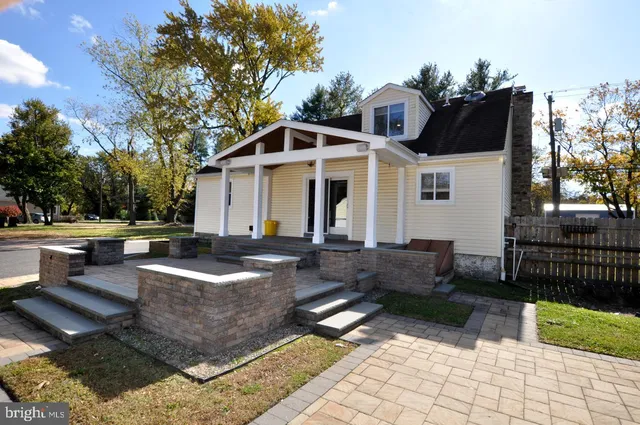 a view of a white house with a yard in front of it