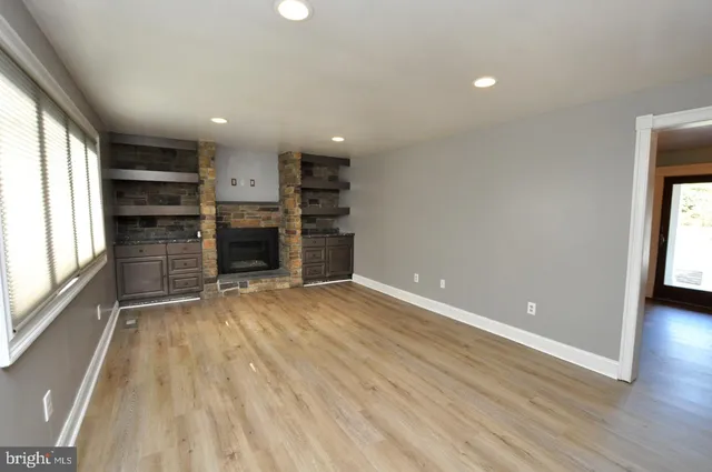 wooden floor in an empty room with a kitchen