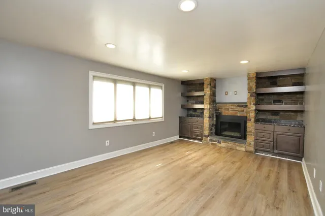 wooden floor in an empty room with a kitchen