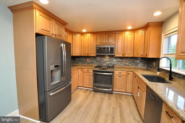 a kitchen with stainless steel appliances a refrigerator sink and microwave
