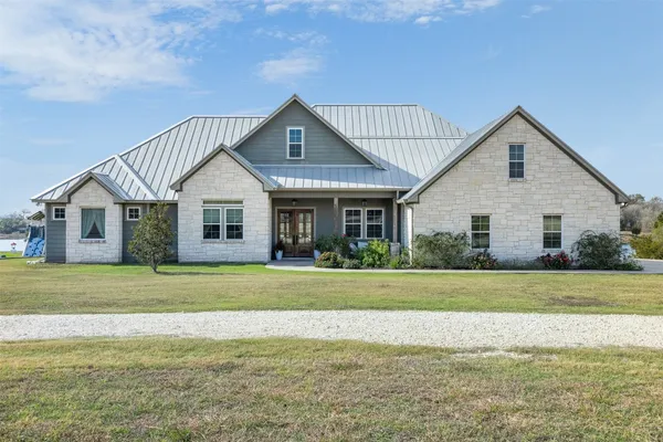 a front view of a house with a yard and trees