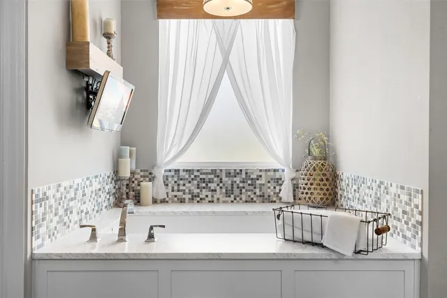 a bathroom with a bathtub and next to a window