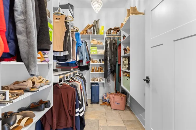 a view of walk in closet with clothes and shoes