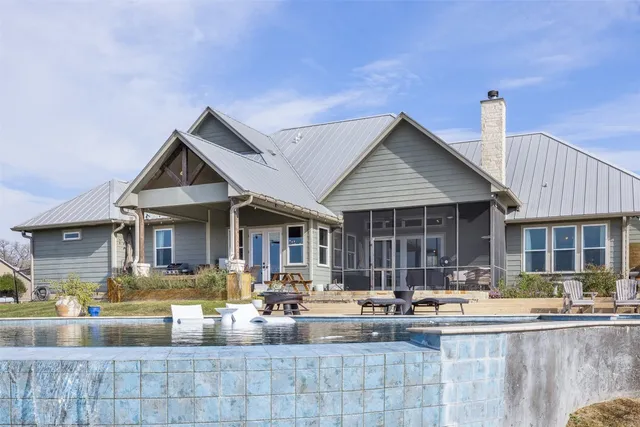 a view of a house with swimming pool and sitting area
