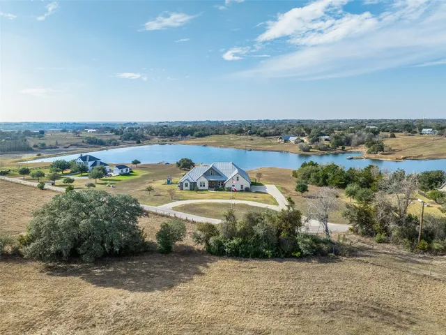 an aerial view of lake and residential houses with outdoor space