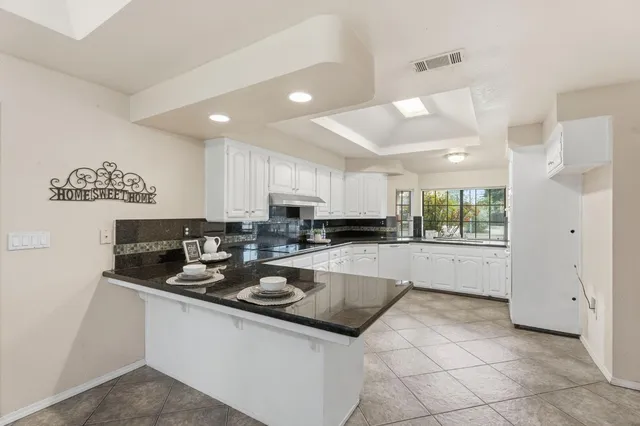 an empty room with a chandelier fan and closet area
