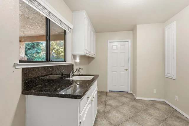 a sign that is sitting on a sidewalk in front of the house