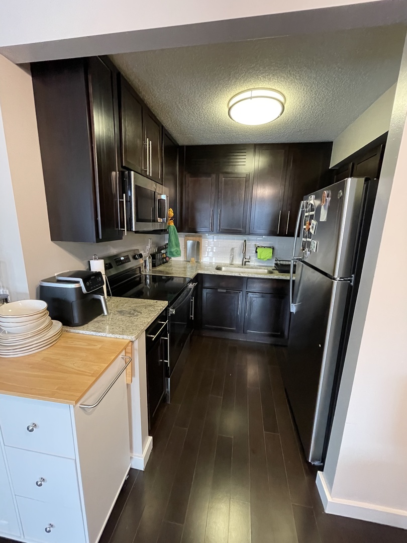 77 West Huron Street, Unit 1803 Chicago, IL 60654 - Photo 5 of 22 a kitchen with stainless steel appliances granite countertop a sink stove and refrigerator