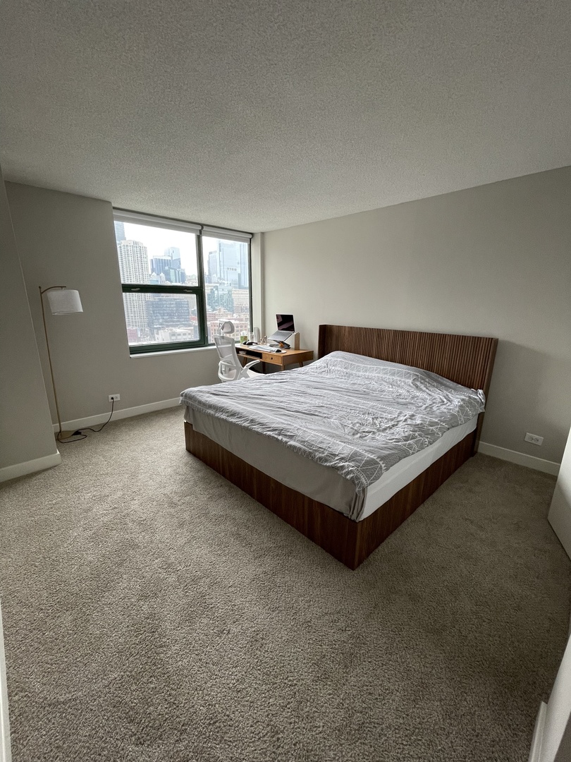 77 West Huron Street, Unit 1803 Chicago, IL 60654 - Photo 8 of 22 a bed sitting in a spacious bedroom next to a window